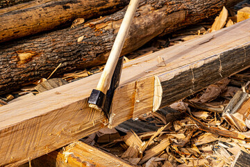 an ax for chopping wood is stuck in a log