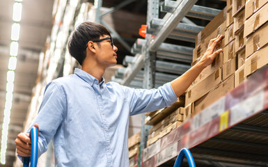 Portrait engineer worker labor asian man shipping order detail check goods and supplies on shelves with goods background inventory in factory warehouse.logistic industry and business export