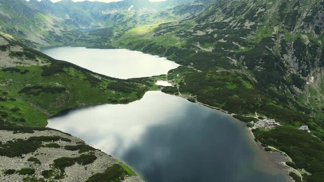 Flying High Above the Water and a Sea of Fog at Sunrise over the mountains. Morskie Oko lake in Tatra Mountains. Flying over the clouds. Lush Scenery and Magnificent Mountain Range With two lakes