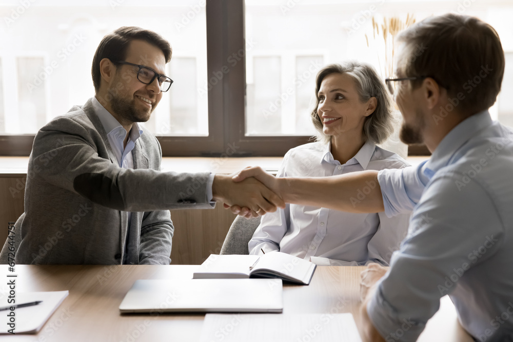 Poster team of business partners shaking hands after successful discussion, smiling, reaching agreement, gi