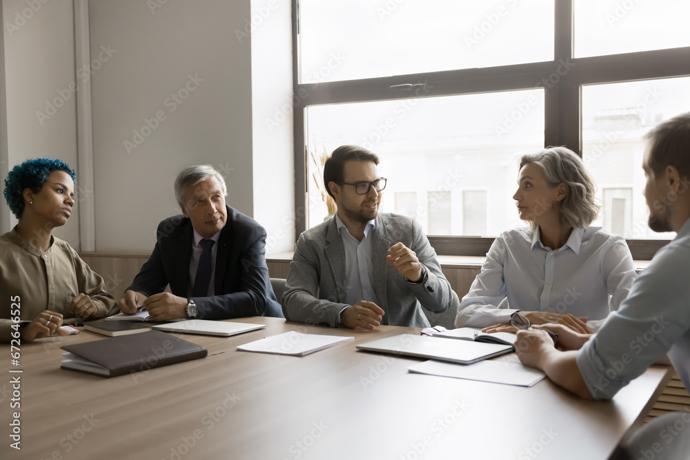 Poster Diverse modern business team working on project together, brainstorming on plan, strategy, creative ideas, discussing cooperation, teamwork. Boss talking to elder employees on meeting