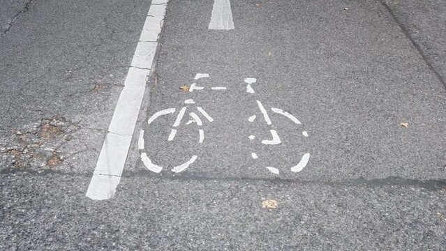 White bicycle signs on ground in timelapse match cut technique, concept for urban mobility. Alternative transportation, bike lane, bikeway, street sign.	