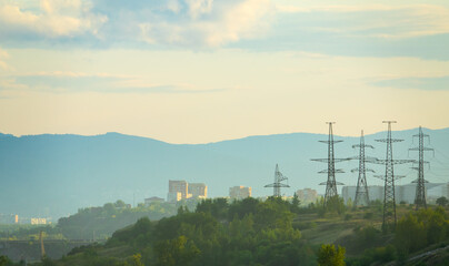 High-voltage pylons and a city on the mountain