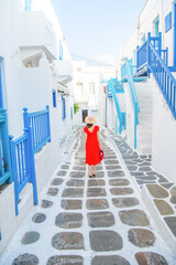 Woman in red dress at the Streets of old town Mykonos during a vacation in Greece, Little Venice Mykonos Greece