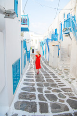 Woman in red dress at the Streets of old town Mykonos during a vacation in Greece, Little Venice Mykonos Greece