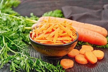 Carrots grated in bowl on board