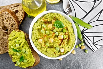 Foto op Plexiglas Hummus from green peas in bowl on stone table top © kostrez