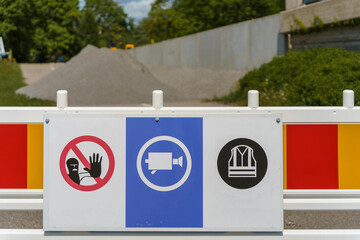 Safety signs on a construction barrier in a work site.