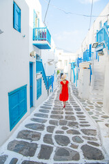 Woman in red dress at the Streets of old town Mykonos during a vacation in Greece, Little Venice Mykonos Greece
