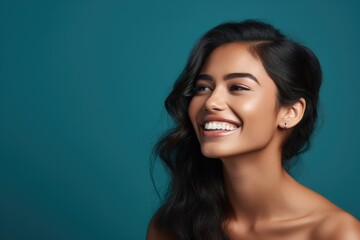 Fototapeta premium Black beautiful model teenage woman with curly hair dressed in orange tak top laughing and smiling in front of a teal wall, funny, happiness, joy, enjoy life