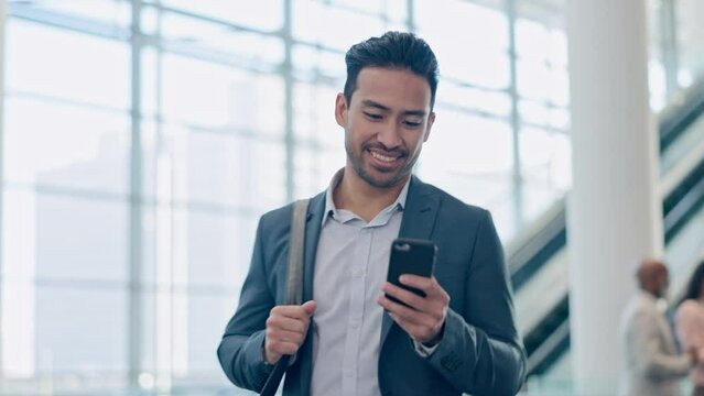 Phone, smile and business man at airport lobby for social media, search app or email. Happy, smartphone and Asian professional with bag or luggage for travel, communication and consultant walking - Powered by Adobe