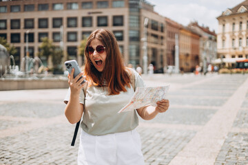 Negative people emotion. Upset young 30s woman with map is using a smartphone outdoors. Phone Communication. Urban lifestyle concept. Traveler