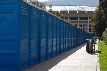 Blue plastic public restroom stalls in the park.