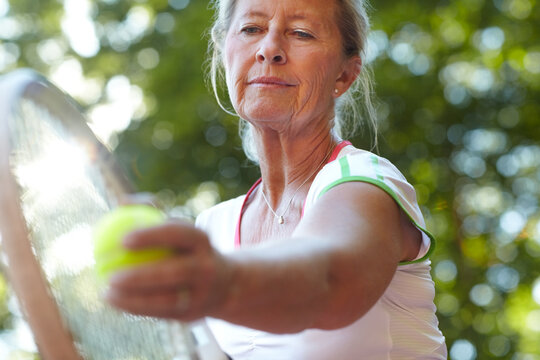 Woman, tennis racket and ball closeup for serve sport for workout, game play or match. Mature, female person and exercise hand or bat on fitness court for retirement cardio or hobby, fun in summer