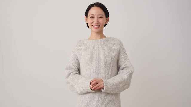 笑顔でお辞儀をする中年女性　白背景　カメラ目線