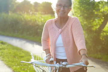 Portrait, smile and elderly woman on bike outdoor, exercise and fitness in summer. Happy, senior...