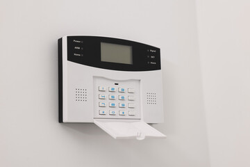 Home security alarm system on white wall indoors