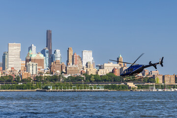 Helicopter taking off, flying towards Brooklyn Heights over the East River, New York City, USA