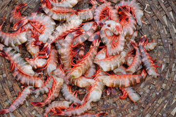 Close-up view of fresh red Tiger shrimp or Bagda Chingri piled in a bamboo basket.
