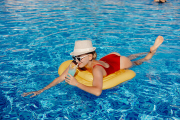 woman in a bikini with a cocktail in the pool