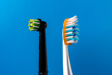 Electric and manual toothbrushes on a blue background