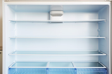 An open empty fridge in a kitchen. Hungry and food price concept