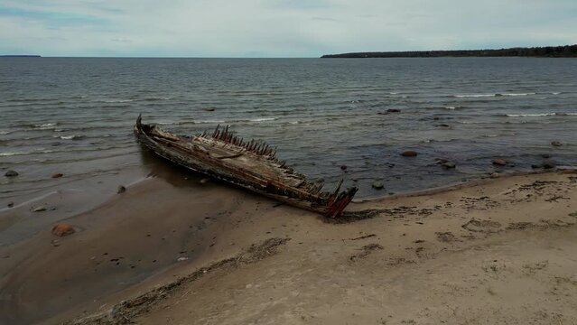 Abandoned shipwreck, An abandoned broken boat full of holes lying on the seashore. Wreck ship on reefs in sea or ocean. The sunken ship, the ship ran aground. Ecological disaster of the Aral Sea.