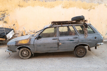 une vieille voiture dans une rue coloniale de le vieille ville de Saint Louis au Sénégal - obrazy, fototapety, plakaty