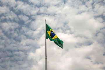 Uma Bandeira do Brasil tremulando ao vento em um dia nublado.