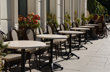 two young girls in an empty street cafe next to empty tables. selective focus . High quality photo