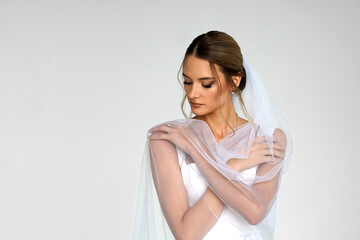 The bride in a white wedding dress with a veil. A girl in a wedding dress. a photo for a wedding...