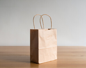 A single paper bag resting on a wooden table