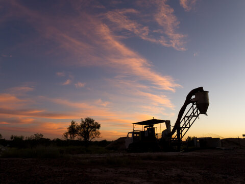 Opal extraction machinery silhouetted against sunset