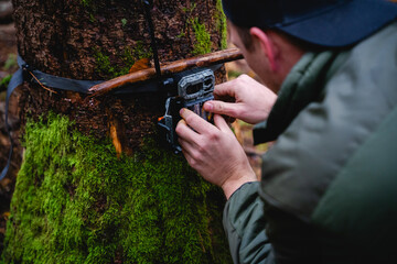 Hunter attaches wildlife camera to tree
