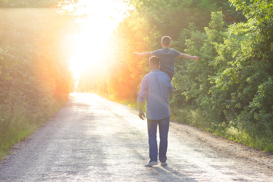 father and son walking on the road