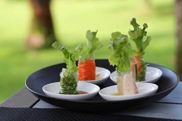 Fresh roll, Fresh vegetable salad roll bite sized and served on small plate with spicy dipping...