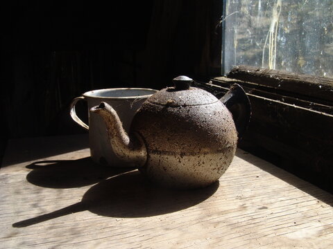 Old rustic teapot and enamel mug