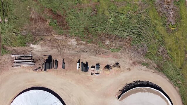 Drone view over two grain storage piles being filled and covered