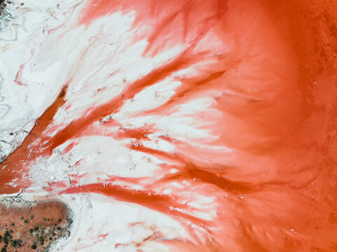 Aerial View A Colourful Pattern Of Red Water Radiating Into A Salt Lake