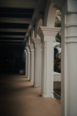 Large building, featuring a long hallway lined with white columns