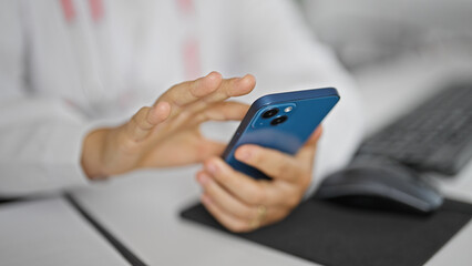 Young beautiful hispanic woman doctor using smartphone at clinic