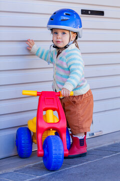 Young Australian toddler ready to ride tricycle outside