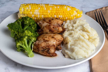 chicken thighs  with mashed potatoes and broccoli,