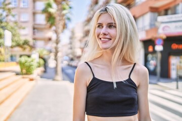 Young blonde woman smiling confident looking to the side at street