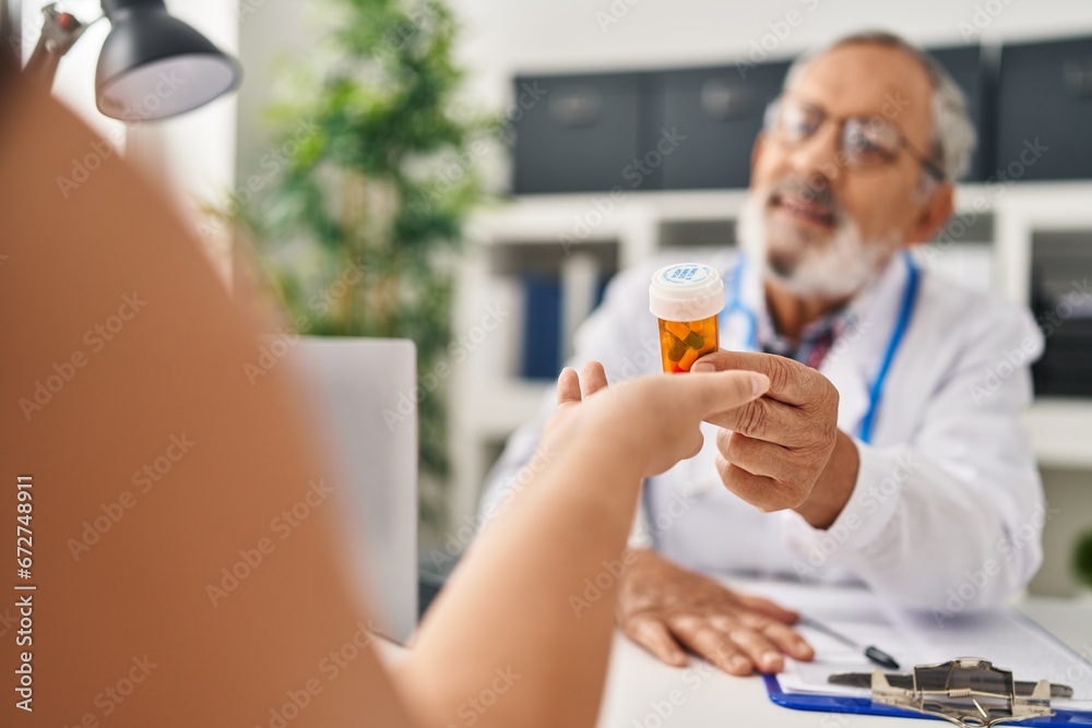 Sticker Senior grey-haired man doctor smiling confident prescribe pills at clinic