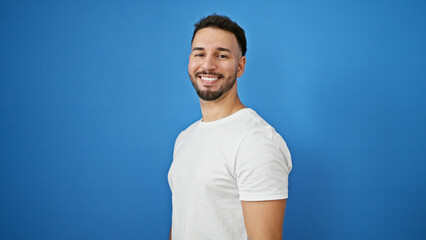 Young arab man smiling confident standing over isolated blue background