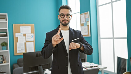 Young arab man business worker looking watch saying no with finger at the office