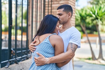 Obraz premium Man and woman couple smiling confident hugging each other at street