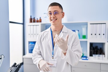 Young hispanic man scientist smiling confident speaking at laboratory