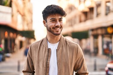 Obraz premium Young hispanic man smiling confident looking to the side at street